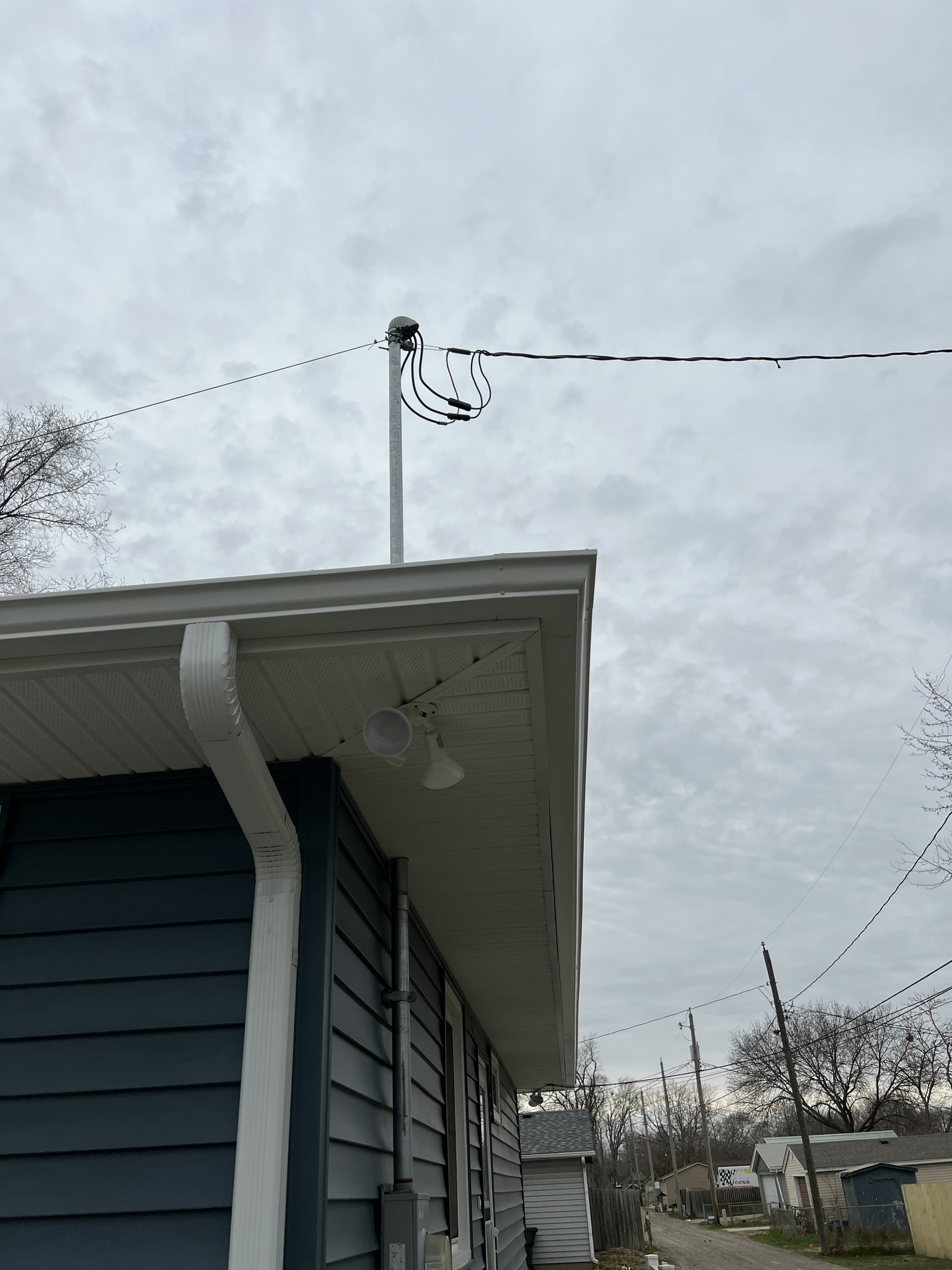 Blue residential siding with white gutter and roof edge detail.