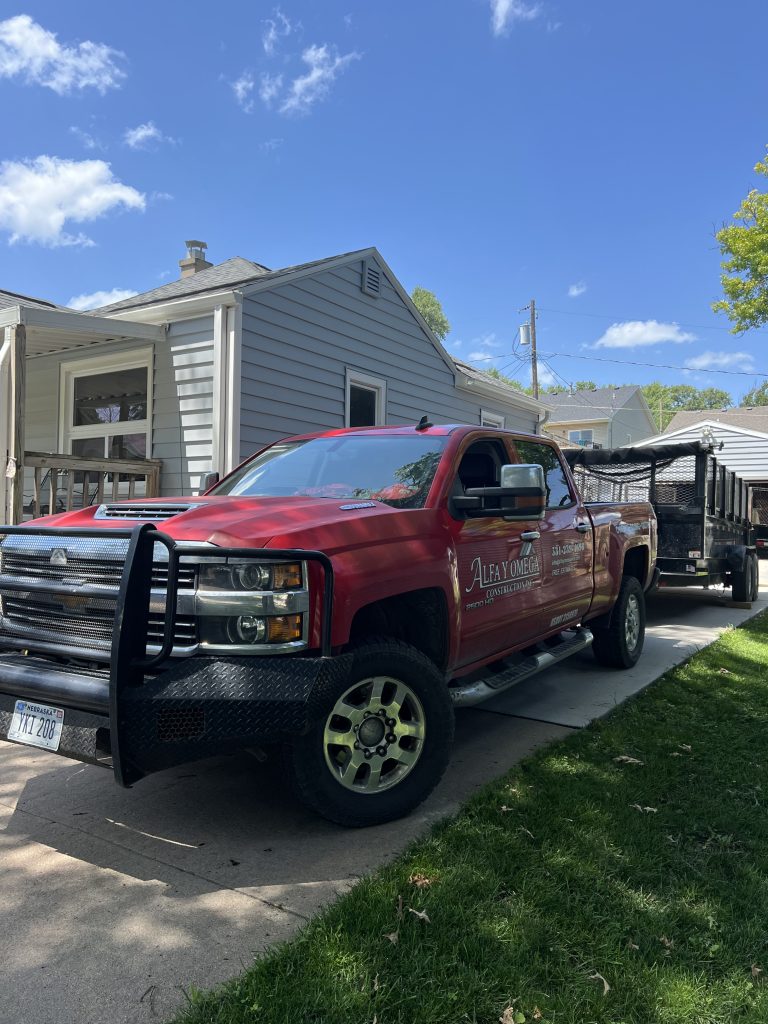 Alfa y Omega truck and trailer at a residential exterior project.