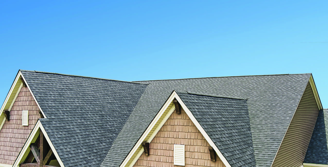 Gray architectural shingles across the gabled roof of a finished home, shown in Atlas manufacturer photography.