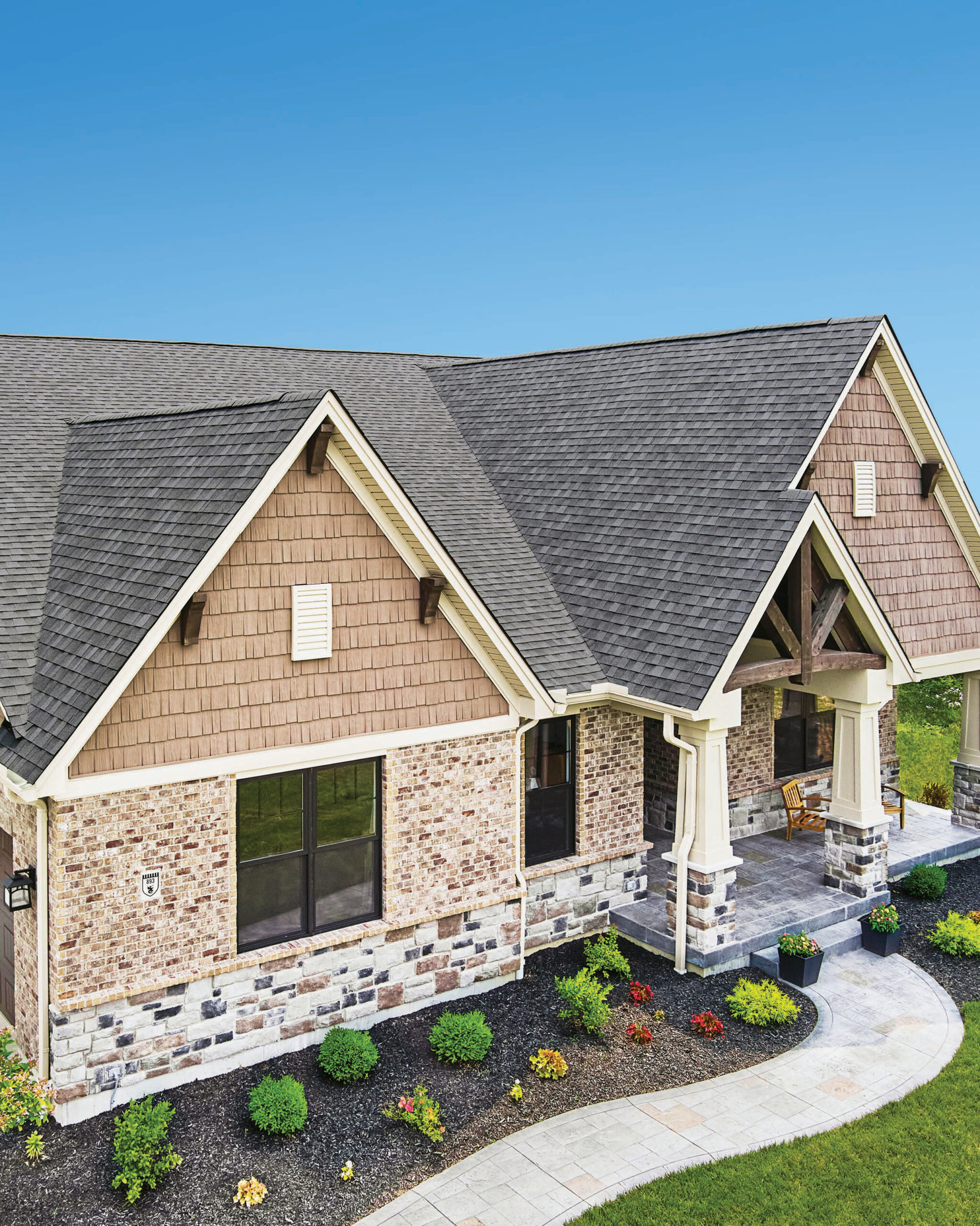 Completed home exterior featuring Atlas Pinnacle Impact shingles in Pewter IR. Manufacturer photograph.